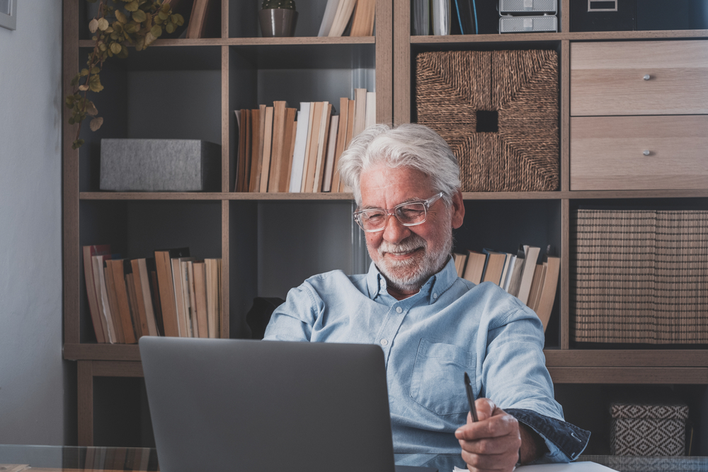 elderly male on his laptop smiling