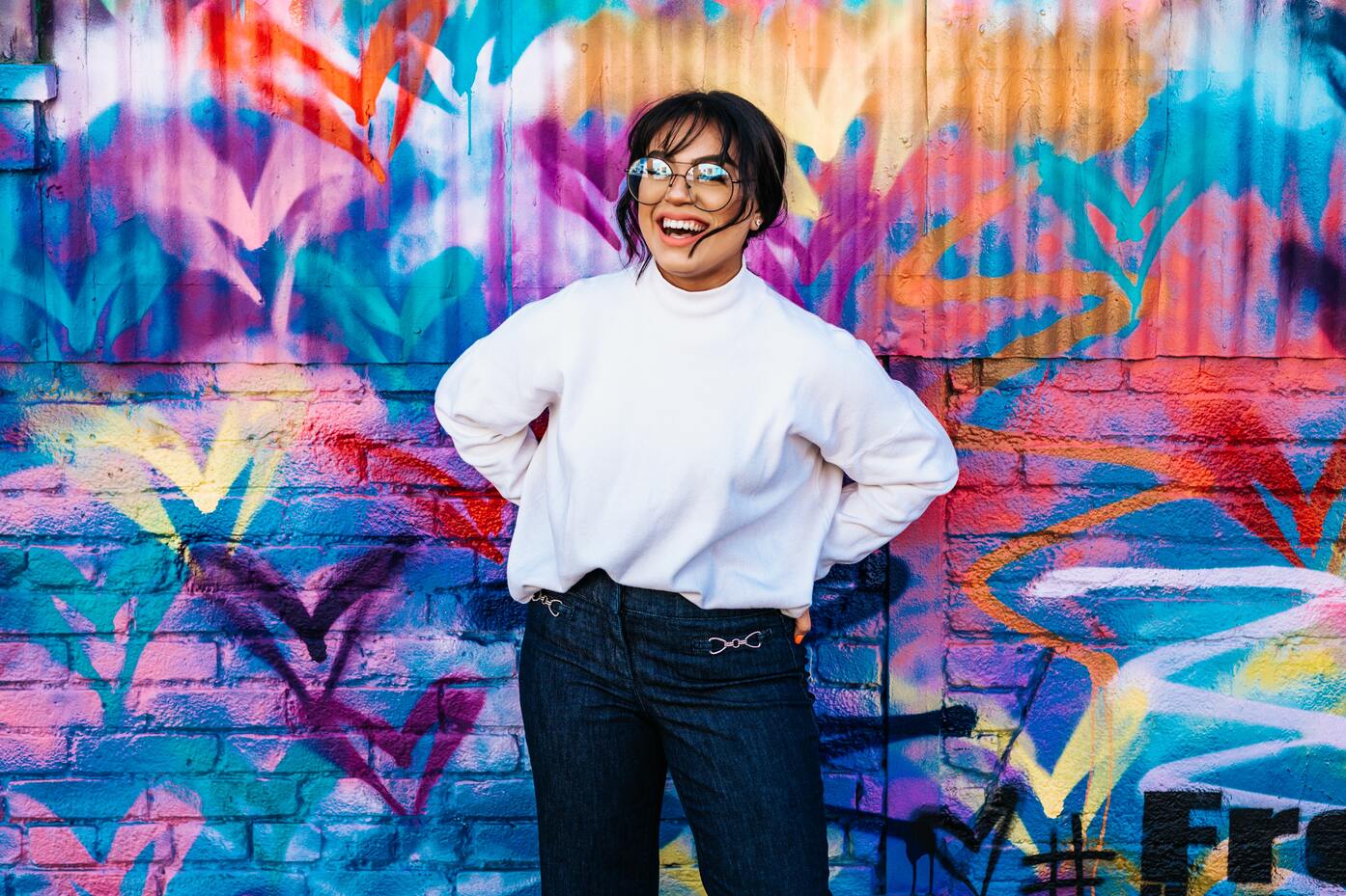 smiling women infront of a colourful wall